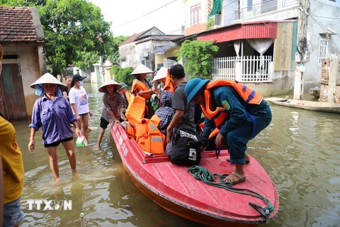 Người dân xóm Bến Vôi, thôn Cấn Hạ, xã Cấn Hữu được di chuyển bằng cano trong khi chờ nước rút. (Ảnh Mạnh Khánh/TTXVN)