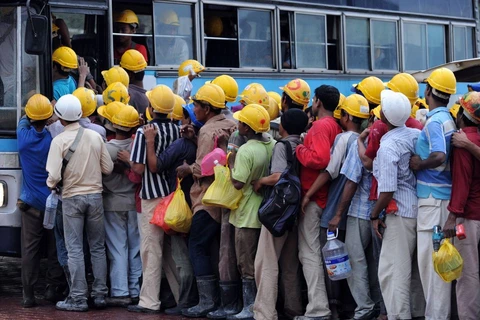 Các công nhân người Bangladesh lên xe buýt sau khi hết ca làm việc một công trường xây dựng ở Kuala Lumpur. (Nguồn: AFP) 