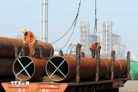  Công nhân vận chuyển thép tại một cảng ở thành phố Liên vận cảng, tỉnh Giang Tô, Trung Quốc. (Nguồn: AFP/TTXVN)