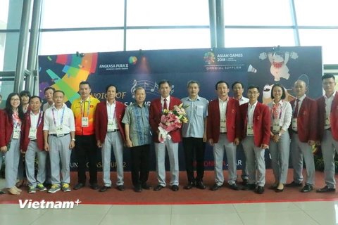 Đại diện Đại sứ quán Việt Nam tại Indonesia tặng hoa đoàn tại sân bay. (Ảnh: Đỗ Quyên/Vietnam+)
