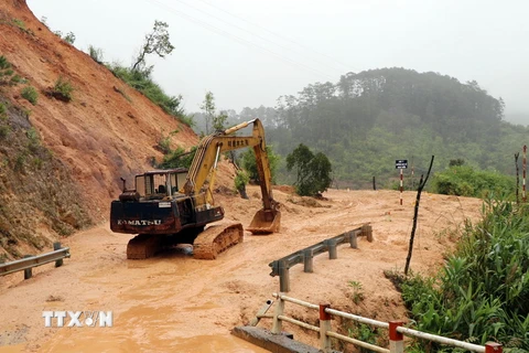 Máy xúc thu dọn đất đá trên tuyến Quốc lộ 40B đoạn qua huyện Tu Mơ Rông, tỉnh Kon Tum. (Ảnh: Cao Nguyên/TTXVN)