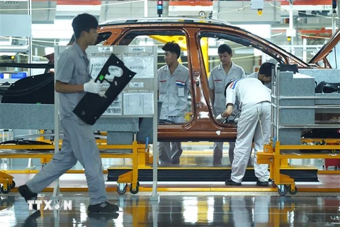 Công nhân làm việc trên dây chuyền lắp ráp ôtô ở Thành Đô, Trung Quốc. (Ảnh: AFP/TTXVN)