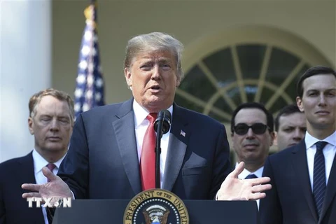 Tổng thống Mỹ Donald Trump (giữa) cùng Đại diện Thương mại Mỹ Robert Lighthizer (trái) phụ trách đàm phán USMCA và các quan chức Chính phủ tại buổi họp báo ở Washington DC., ngày 1/10/2018. (Ảnh: AFP/TTXVN)