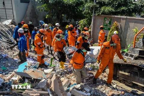 Lực lượng cứu hộ chuyển thi thể nạn nhân ra khỏi đống đổ nát của một tòa nhà bị sập sau thảm họa động đất và sóng thần ở Palu, tỉnh Trung Sulawesi, Indonesia ngày 1/10/2018. (Ảnh: THX/TTXVN)
