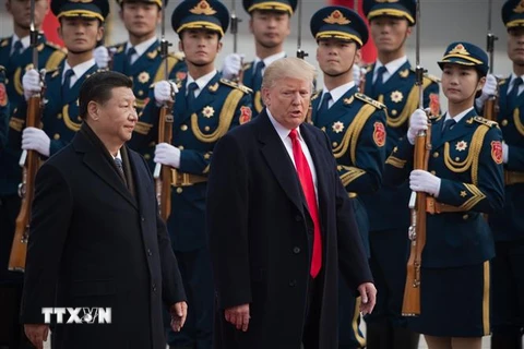 Chủ tịch Trung Quốc Tập Cận Bình (trái) và Tổng thống Mỹ Donald Trump duyệt đội danh dự tại lễ đón ở Bắc Kinh, Trung Quốc ngày 9/11/2017. (Ảnh: AFP/TTXVN)