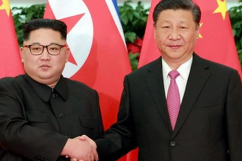 Chủ tịch Trung Quốc Tập Cận Bình (phải) và lãnh đạo Triều Tiên Kim Jong-un bắt tay tại Đại lễ đường Nhân dân ở Bắc Kinh hôm 19/6. (Ảnh: AFP)