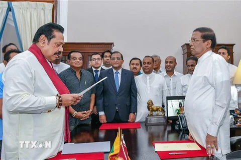 Tổng thống Sri Lanka Maithripala Sirisena (phải) chứng kiến lễ tuyên thệ nhậm chức Thủ tướng mới của ông Mahinda Rajapakse (trái) tại Colombo ngày 26/10/2018. (Ảnh: AFP/TTXVN)