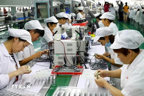 Công nhân làm việc trên dây chuyền sản xuất động cơ siêu nhỏ tại nhà máy ở Hoài Bắc, An Huy, Trung Quốc. (Ảnh: AFP/TTXVN)