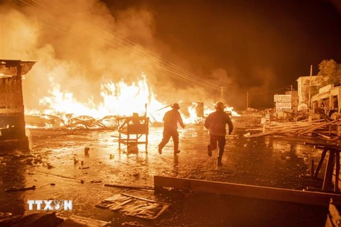 Lính cứu hỏa nỗ lực dập lửa do người biểu tình gây ra trong cuộc bạo loạn tại thủ đô Port-au-Prince, Haiti, ngày 16/2/2019. (Ảnh: EFE/TTXVN)