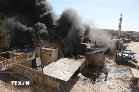 Khói bốc lên sau các cuộc không kích ở thị trấn Khan Sheikhun, tỉnh Idlib, Syria ngày 19/2. (Ảnh: AFP/TTXVN)