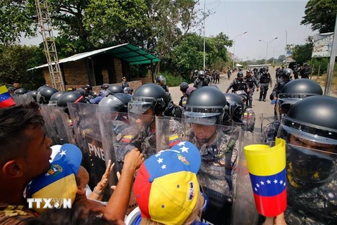 Cảnh sát Venezuela ngăn chặn những người biểu tình quá khích tại khu vực biên giới giữa Venezuela và Colombia ngày 23/2. (Ảnh: AFP/TTXVN)