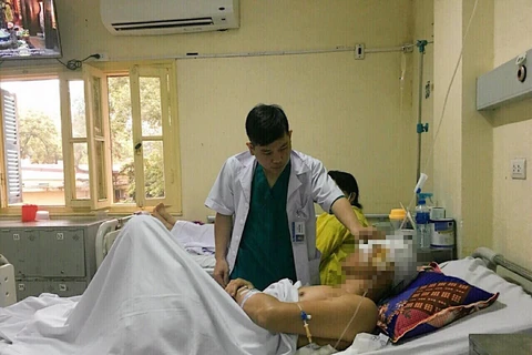 Bác sỹ thăm khám bệnh nhân B.V.M. (Ảnh: PV/Vietnam+)