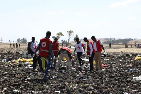 Nhân viên Chữ Thập Đỏ dọn dẹp tại hiện trường vụ tai nạn máy bay của hãng hàng không Ethiopia Airlines tại Bishoftu, Ethiopia. (Ảnh: AFP/TTXVN)