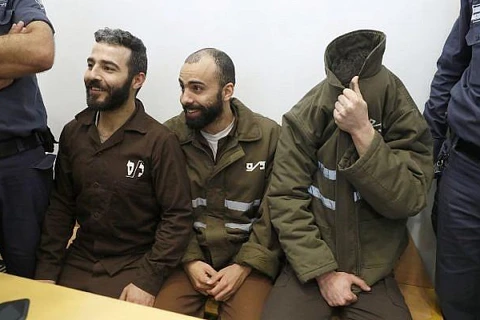 Nhân viên lãnh sự Pháp Romain Franck (phải, bịt mặt), khi đó 24 tuổi, cùng các đồng phạm người Palestin Moufak al-Ajluni (trái) và Mohamed Katout (giữa) xuất hiện tại tòa án ở thành phố Haifa của Israel vào ngày 19/3/2018 với tội danh buôn lậu súng từ Gaz