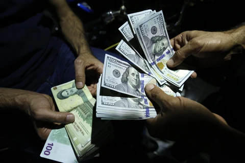 Giao dịch đổi đồng Rials của Iran và đồng đôla Mỹ tại một cửa hàng ngoại hối ở thủ đô Tehran, Iran. (Ảnh: AFP/TTXVN)