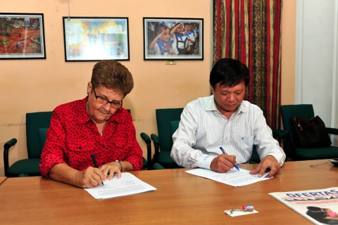 Phó Tổng giám đốc TTXVN Đinh Đăng Quang và Giám đốc Cuba ACN Edda Diz Garcés ký kết biên bản bàn giao trang thiết bị tác nghiệp. (Ảnh: Vũ Lê Hà/TTXVN)