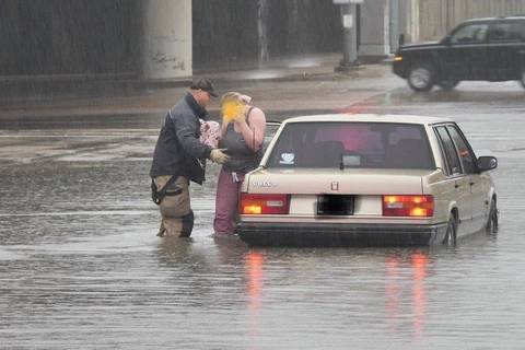 Nhân viên cứu hộ hỗ trợ một công dân bị mắc kẹt trong nước lũ. (Nguồn: accuweather.com)