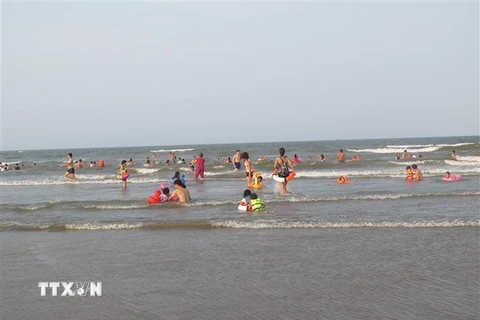 Du khách tắm biển ở bãi biển Xuân Hải huyện Lộc Hà, Hà Tĩnh. (Ảnh: Công Tường-TTXVN)