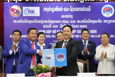 Chủ tịch BACI Nguyễn Thế Hiền (phải) và Chủ tịch YEAL Khamsen Sisavong trao văn kiện ký kết hợp tác. Ảnh: Xuân Tú/TTXVN)