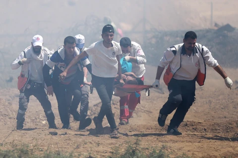 Nhân viên y tế chuyển người biểu tình Palestine bị thương trong cuộc đụng độ với binh sỹ Israel tại biên giới Dải Gaza - Israel ngày 15/5/2019. (Ảnh: THX/ TTXVN)
