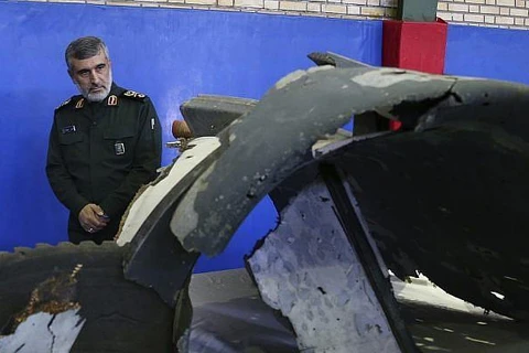 Tướng Amir Ali Hajizadeh xem xét các mảnh vỡ từ chiếc máy bay không người lái của Mỹ bị bắn hạ hôm 20/6. (Nguồn: AP)