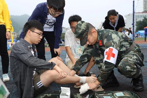 Binh sỹ Trung Quốc giúp đỡ người bị thương sau trận động đất ở Nghi Tân, tỉnh Tứ Xuyên, Trung Quốc ngày 18/6. (Ảnh: THX/TTXVN)