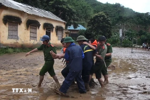 Lực lượng cứu hộ đưa em Nguyễn Minh Lâm bị đa chấn thương từ bản Sa Ná ra ngoài để chữa trị. (Ảnh: TTXVN)