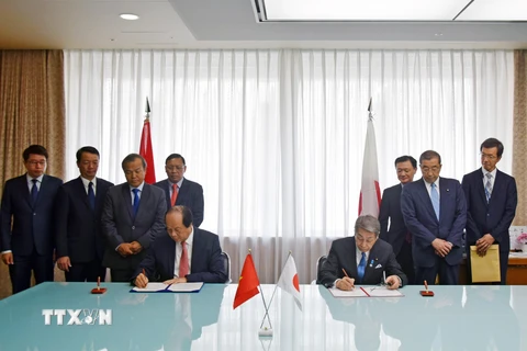 Bộ trưởng, Chủ nhiệm Văn phòng Chính phủ Mai Tiến Dũng và Bộ trưởng Nội vụ và Truyền thông Nhật Bản Masatoshi Ishida ký kết Bản ghi nhớ hợp tác về việc triển khai Chính phủ điện tử tại Việt Nam. (Ảnh: Đào Tùng/TTXVN)