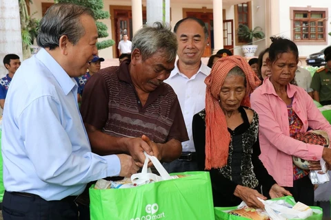 Phó Thủ tướng Thường trực Trương Hòa Bình thăm hỏi, tặng quà cho bà con dân tộc thiểu số tại huyện Lộc Ninh, tỉnh Bình Phước. (Ảnh: Dương Chí Tưởng/TTXVN)
