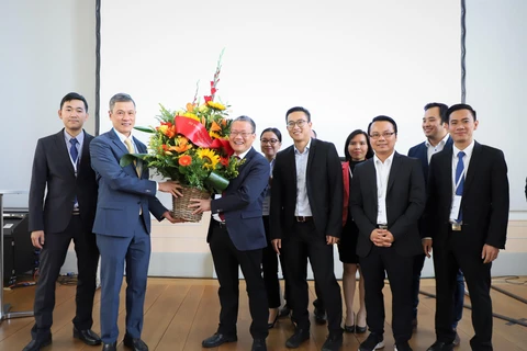 Đại sứ Việt Nam tại Đức Nguyễn Minh Vũ (trái) trao lẵng hoa chúc mừng Ban trù bị Mạng lưới Đổi mới sáng tạo Việt Đức - VGI Network. (Ảnh: Thanh Bình/TTXVN)
