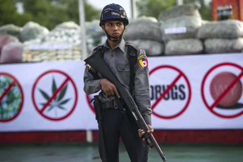 Cảnh sát Myanmar gác bên số tang vật ma túy chuẩn bị được thiêu hủy. (Ảnh: AFP/ TTXVN)