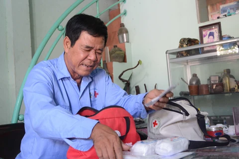 Ông Đặng Thanh Kinh, thành viên của đội "Xe ôm an toàn" thường xuyên kiểm tra túi sơ cứu. (Ảnh: Văn Dũng/TTXVN)
