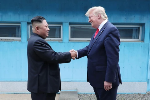 Tổng thống Mỹ Donald Trump (phải) và nhà lãnh đạo Triều Tiên Kim Jong-un trong cuộc gặp thượng đỉnh tại làng đình chiến Panmunjom trong Khu phi quân sự (DMZ) ngày 30/6/2019. (Ảnh: AFP/ TTXVN)