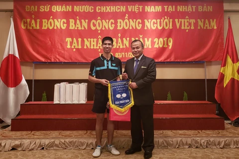 Đại sứ Việt Nam tại Nhật Bản Vũ Hồng Nam trao giải cho vận động viên vô địch nội dung đơn nam. (Ảnh: Thanh Tùng/TTXVN)