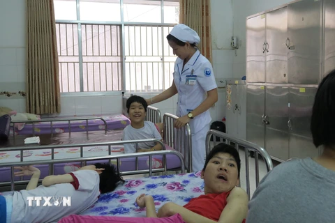 Chăm sóc trẻ khuyết tật do ảnh hưởng chất độc da cam/dioxin tại Làng Hòa Bình, Thành phố Hồ Chí Minh. (Ảnh: Đinh Hằng/TTXVN)