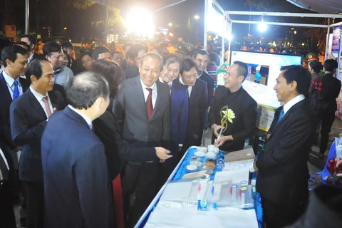 Phó Thủ tướng Trương Hòa Bình và các đại biểu tham quan các gian trưng bày tại sự kiện. (Ảnh: Dư Toán/TTXVN)