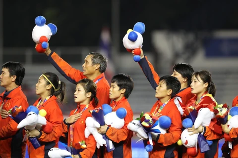 Đội tuyển nữ Việt Nam hát Quốc ca trên bục nhận huy chương. (Ảnh: Hoàng Linh/TTXVN)