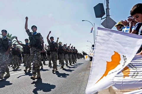 Người dân ở Nicosia vẫy cờ trong một cuộc diễu hành quân sự kỷ niệm 59 năm độc lập của Cyprus khỏi ách thống trị của thực dân Anh tháng 10/2019. (Nguồn: AFP)