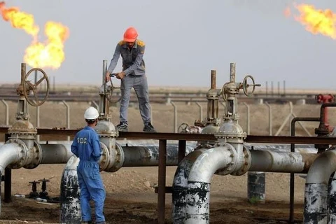 Công nhân làm việc tại một mỏ dầu ở thị trấn Nassiriya, miền Nam Iraq. (Ảnh: AFP/TTXVN)