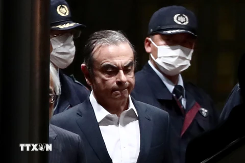 Cảnh sát áp giải cựu Chủ tịch Nissan Carlos Ghosn (giữa) rời khỏi khu giam giữ ở Tokyo, sau khi ông được trả tự do có bảo lãnh, ngày 25/4/2019. (Ảnh: AFP/TTXVN)