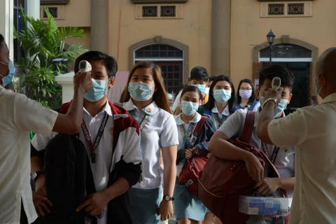 Các sinh viên đeo khẩu trang và được kiểm tra thân nhiệt phòng tránh lây nhiễm virus corona tại một trường học ở Malina, Philippines,ngày 31/1/2020. (Ảnh: AFP/TTXVN)