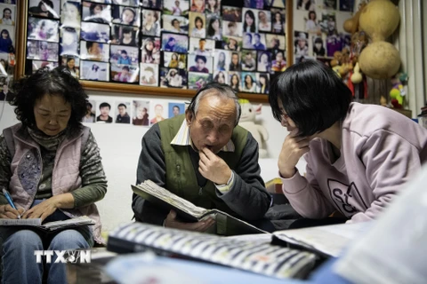Ông mai Zhu Fang (giữa) trò chuyện với một khách hàng tại ngôi nhà ở Bắc Kinh, Trung Quốc, ngày 17/12/2019. (Ảnh: AFP/TTXVN)