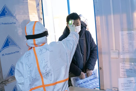Nhân viên y tế kiểm tra thân nhiệt của bệnh nhân nhiễm COVID-19 tại bệnh viện dã chiến ở Vũ Hán, tỉnh Hồ Bắc, Trung Quốc, ngày 10/2/2020. (Ảnh: THX/TTXVN)