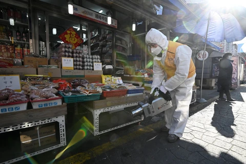 Phun thuốc khử trùng nhằm ngăn chặn sự lây lan của COVID-19 tại khu chợ ở Seoul, Hàn Quốc, ngày 5/2/2020. (Ảnh: AFP/ TTXVN)