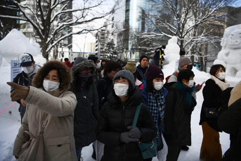 Khách du lịch đeo khẩu trang đề phòng lây nhiễm dịch COVID-19 khi tham quan lễ hội tuyết thường niên tại thành phố Sapporo, Nhật Bản ngày 4/2/2020. (Ảnh: AFP/TTXVN)
