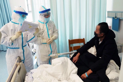 Nhân viên y tế kiểm tra tình trạng bệnh nhân nhiễm COVID-19 đang được điều trị tại một bệnh viện ở Vũ Hán, Trung Quốc ngày 18/2/2020. (Ảnh: THX/TTXVN)