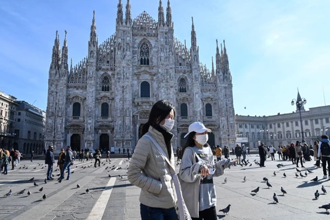 Người dân đeo khẩu trang phòng lây nhiễm dịch viêm đường hô hấp cấp COVID-19 ở Duomo, Milan, Italy ngày 24/2/2020. (Ảnh: AFP/TTXVN)