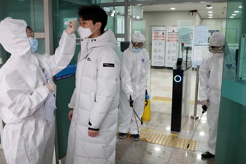 Nhân viên y tế kiểm tra thân nhiệt của sinh viên tại trường đại học Inha ở Incheon, Hàn Quốc, ngày 25/2/2020. (Ảnh: THX/TTXVN)