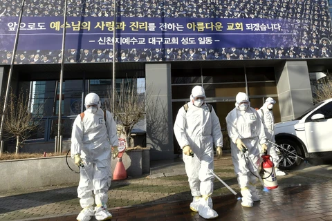 Nhân viên y tế phun thuốc khử trùng phía trước nhà thờ của giáo phái Tân Thiên Địa ở thành phố Daegu, Hàn Quốc ngày 19/2/2020. (Ảnh: AFP/TTXVN)