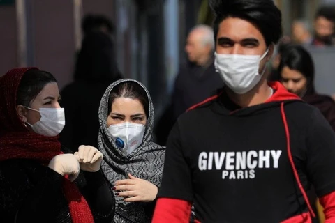 Người dân đeo khẩu trang đề phòng lây nhiễm virus SARS-CoV-2 tại Tehran, Iran ngày 23/2/2020. (Ảnh: AP/TTXVN)